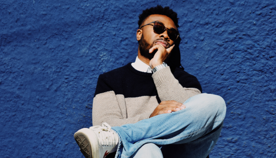 Man seated next to blue wall