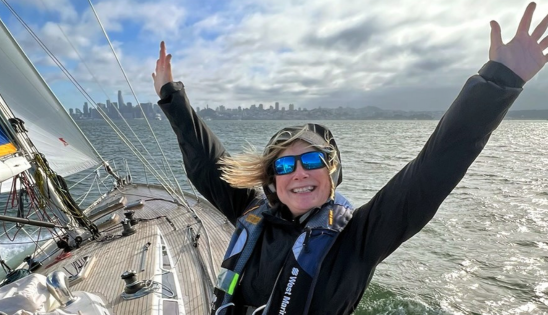 Carol Hink on sailboat with arms up