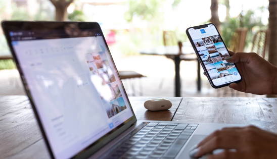 Laptop and hand holding a mobile phone