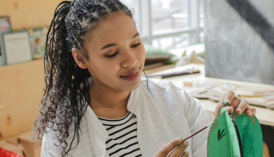 woman painting a sculpture